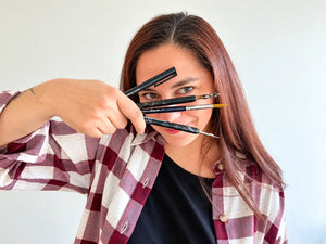 Close caption of artist Maria Vallverdu Sabia holding brushes 