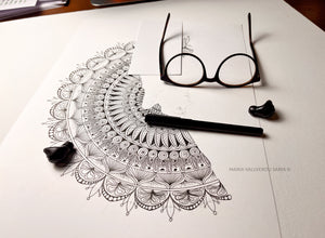 Meditate artwork on paper, glasses and pen by side